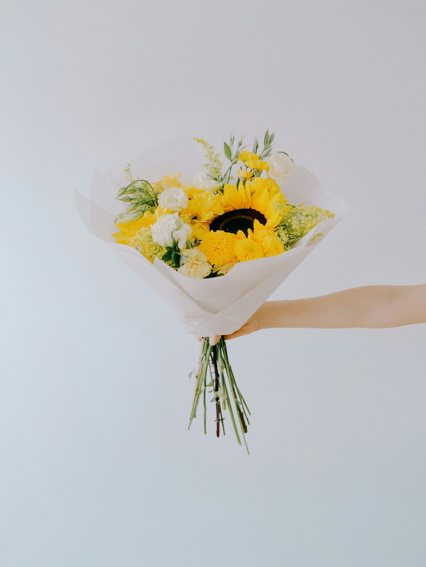 A sunflower bouquet wrapped in white paper