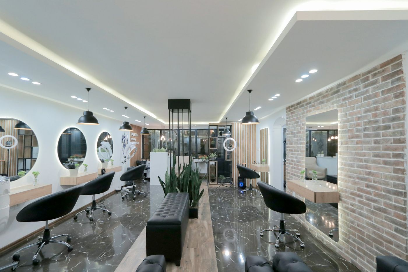 A bright salon with round mirrors and black chairs
