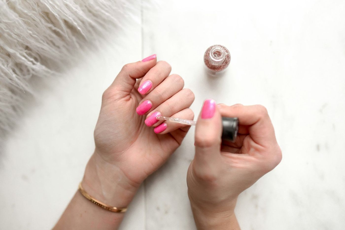 Pink polish being painted onto nails